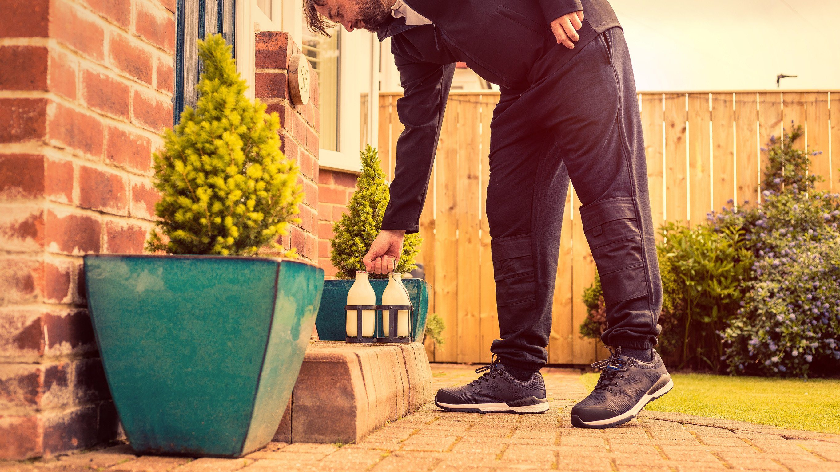 A man putting down milk on a doorstep