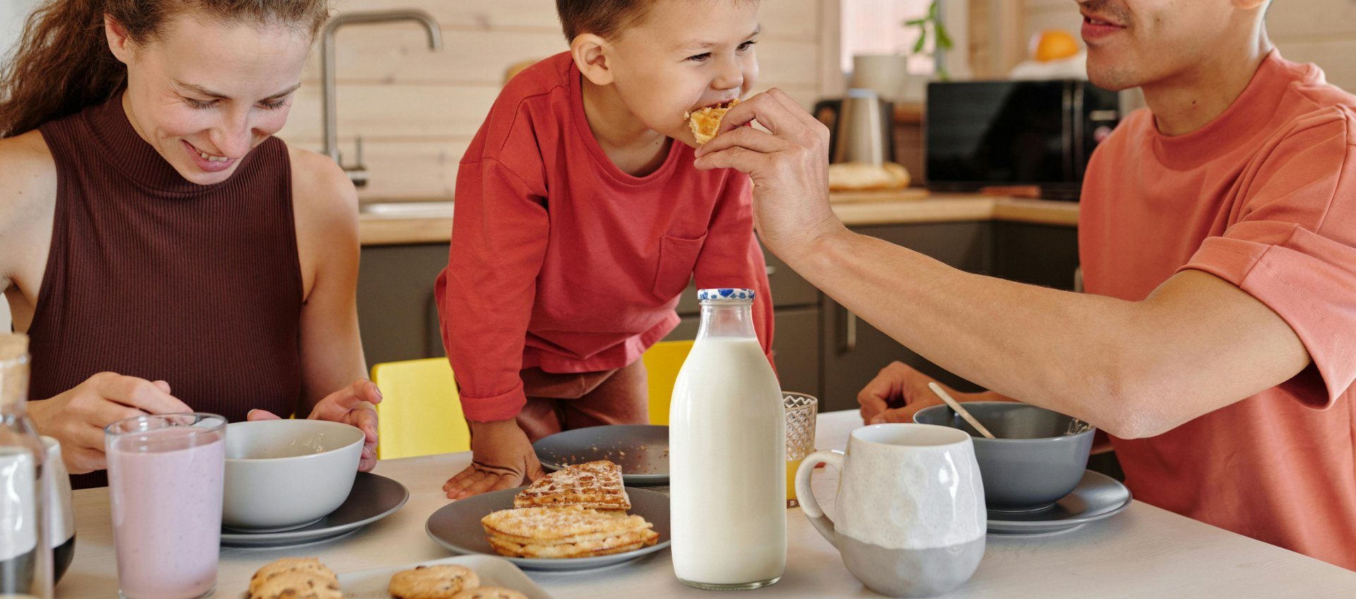A small child being fed at the breakfast table